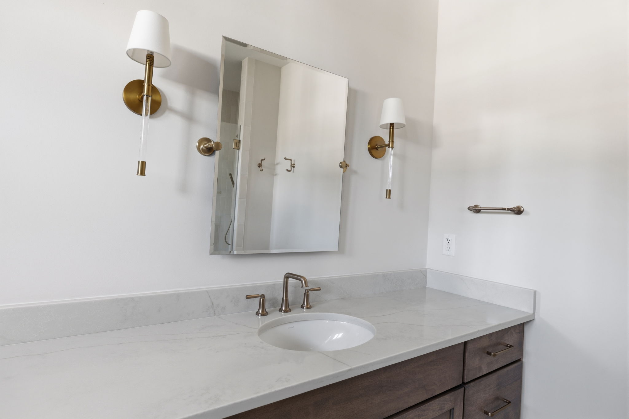 zoomed in on sink, mirror and two sconces